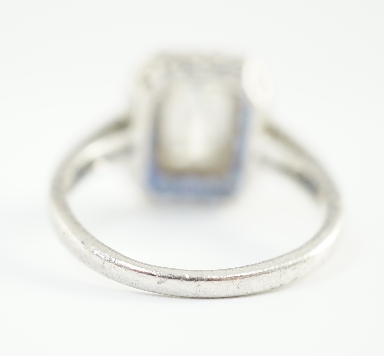 A 1920's platinum and millegrain set single stone emerald cut diamond and sapphire set rectangular cluster ring